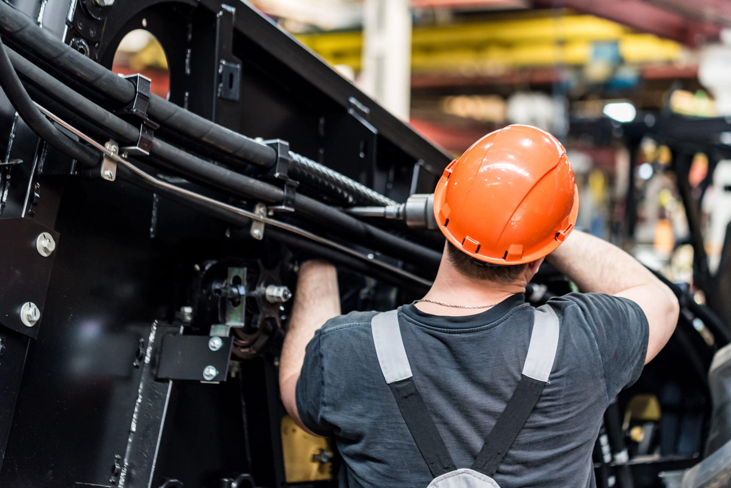Industrial worker assembles agricultural equipment